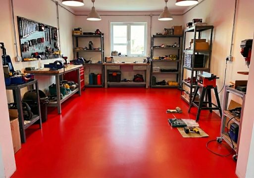 Stylowy warsztat z czerwonymi akcentami i posadzką w kolorze czerwień sygnałowa RAL 3001.