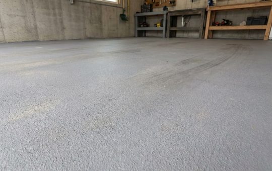 Podłoga w garażu pokryta jest szarą, ziarnistą powłoką w kolorze RAL 7045.